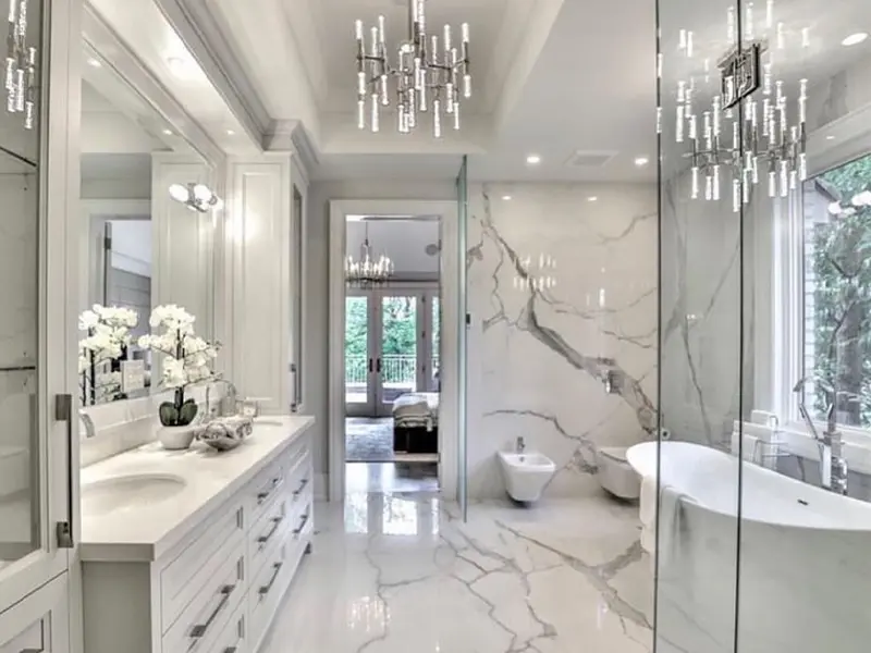 Modern bathroom with marble floors, a freestanding tub, double vanity, and glass shower enclosure.