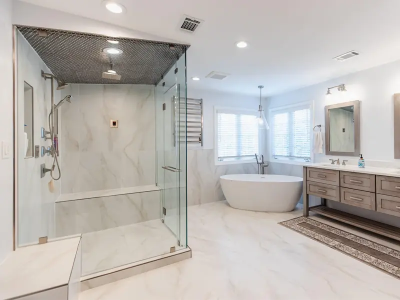 Modern bathroom with a glass shower enclosure, freestanding bathtub, and wooden vanity with mirrors.