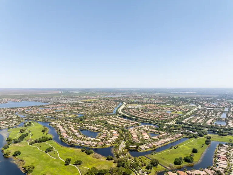 Aerial view of a suburban neighborhood with winding waterways and green spaces.