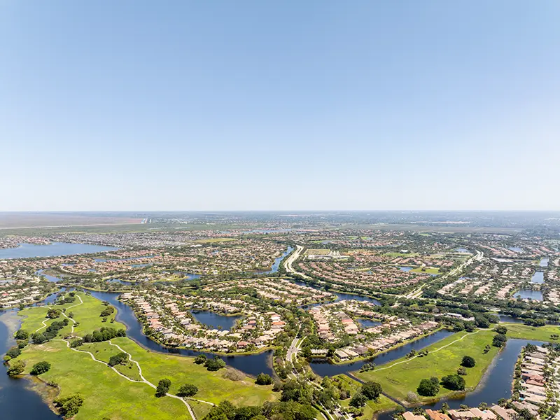 Aerial view of a suburban neighborhood with winding waterways and green spaces.